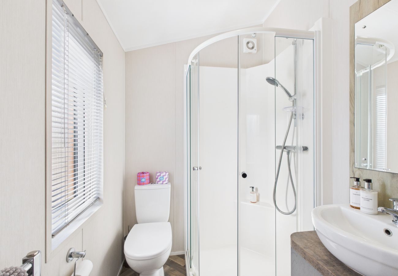 Modern walk-in shower cubicle with contemporary white fixtures.
