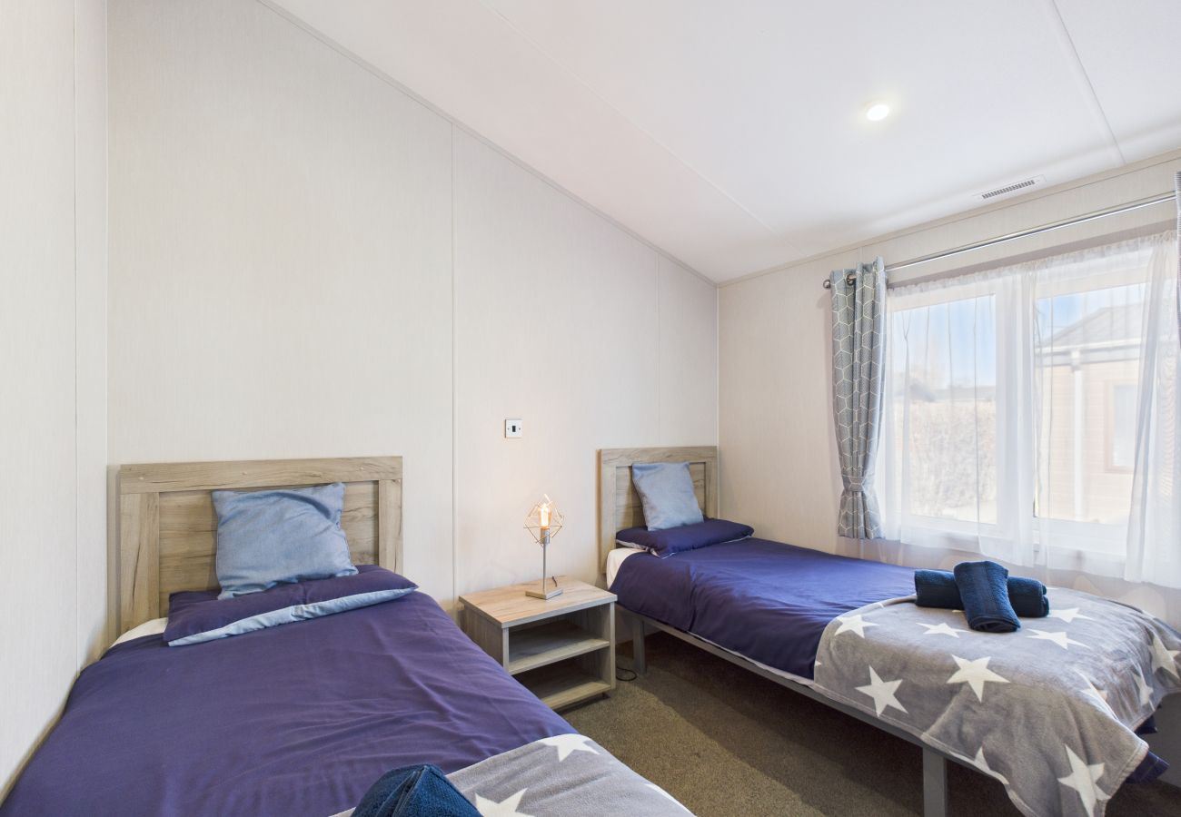 Two single beds with decorative throws in a light-filled room.