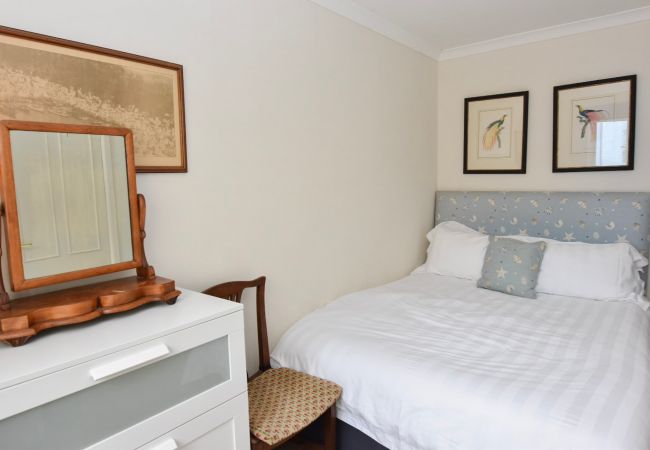 The Cottage Holiday Home Ground floor bedroom with double bed, chest of drawers and wardrobe.