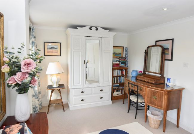 The Cottage Holiday Home Master bedroom with dressing table, wardrobe and library of books.