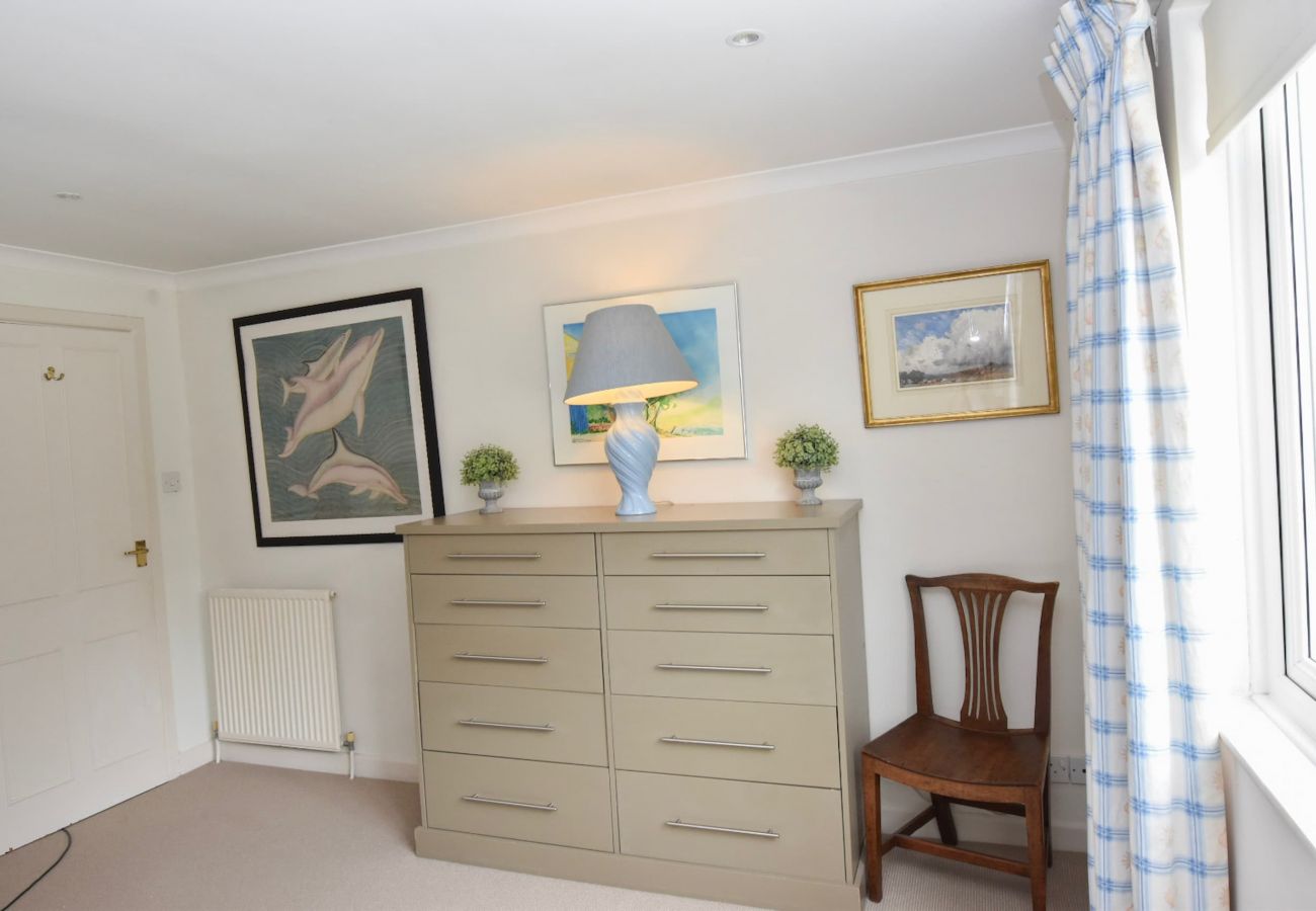 The Cottage Holiday Home twin bedroom with clothes drawer and chair.