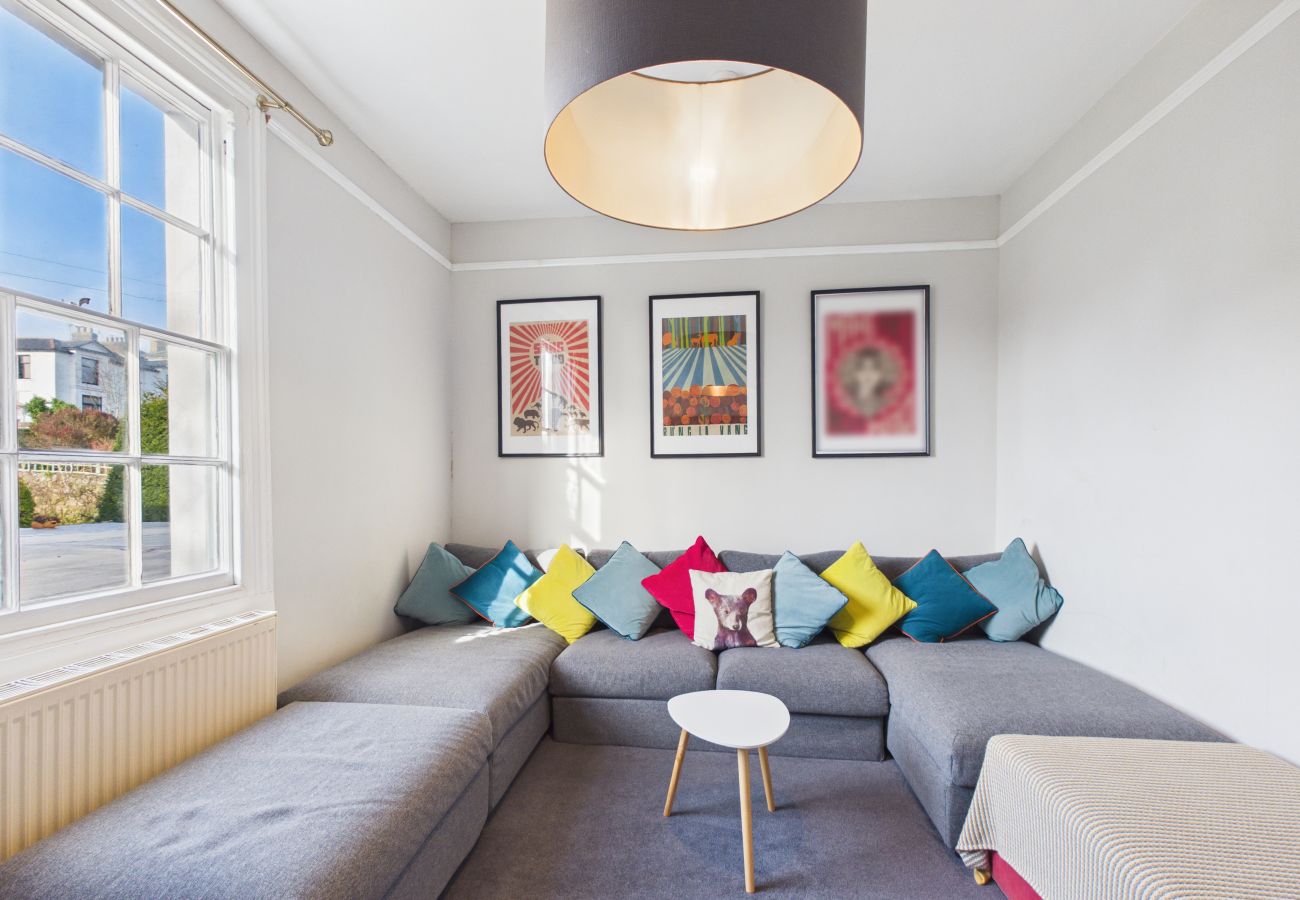 Ryde Modern lounge with a deep grey corner sofa and coastal-themed decorations.