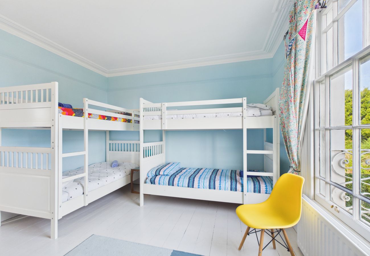 Wooden bunk beds with colorful bedding in a characterful guest room.