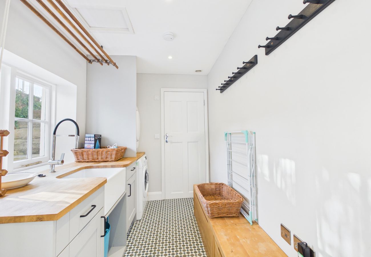 Functional utility room with a sink and laundry appliances, perfect for pet owners.