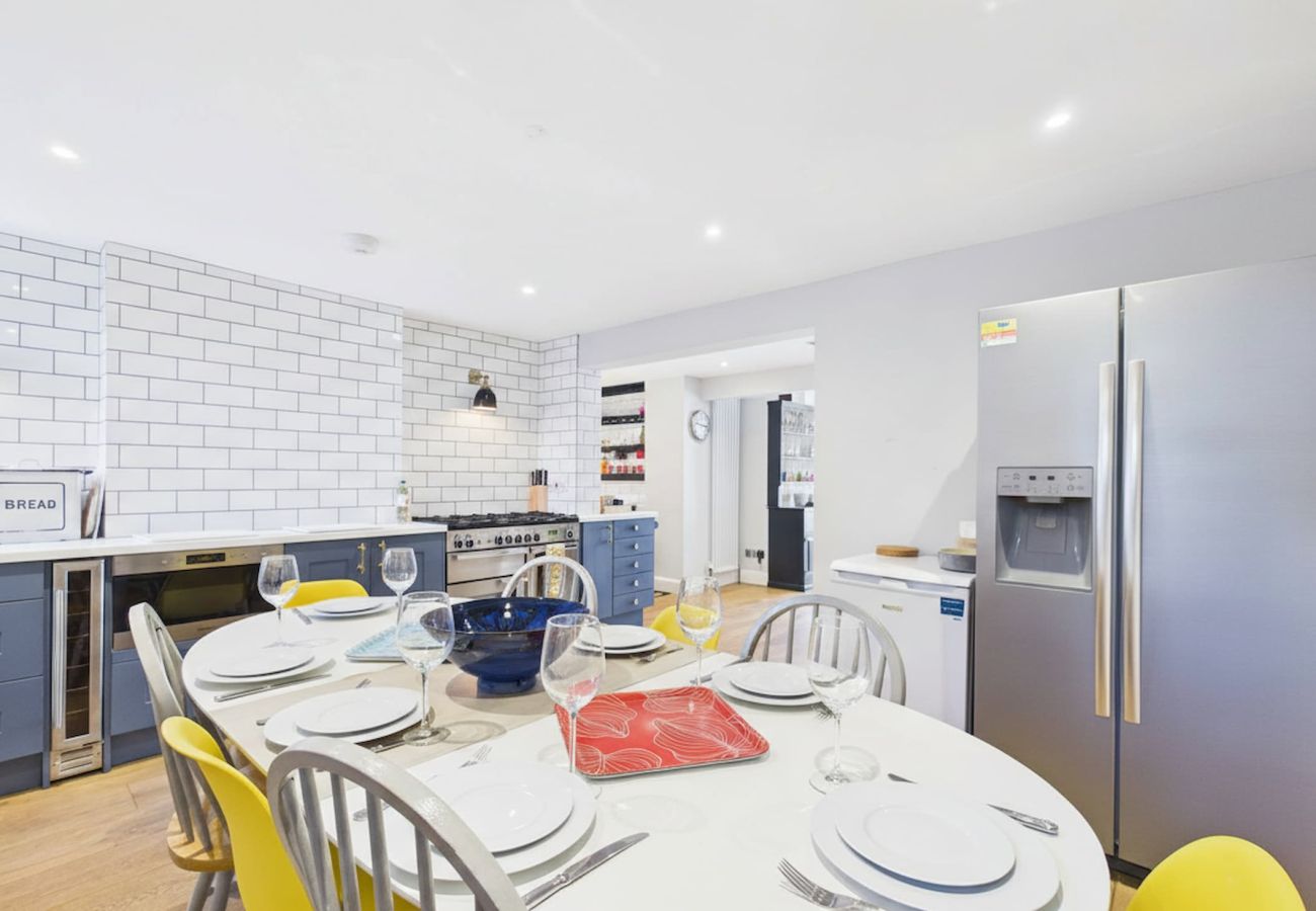 Modern kitchen space with a large wooden dining table and contemporary chairs.