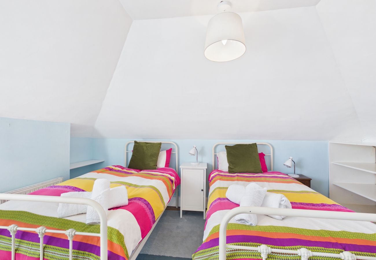 Two single beds in a bright bedroom.