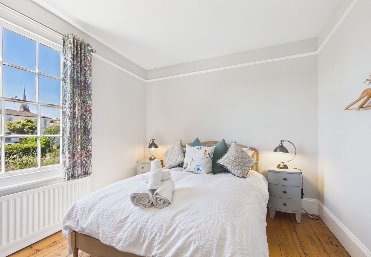 Comfortable double bed with bedside lamps in a character-filled room.
