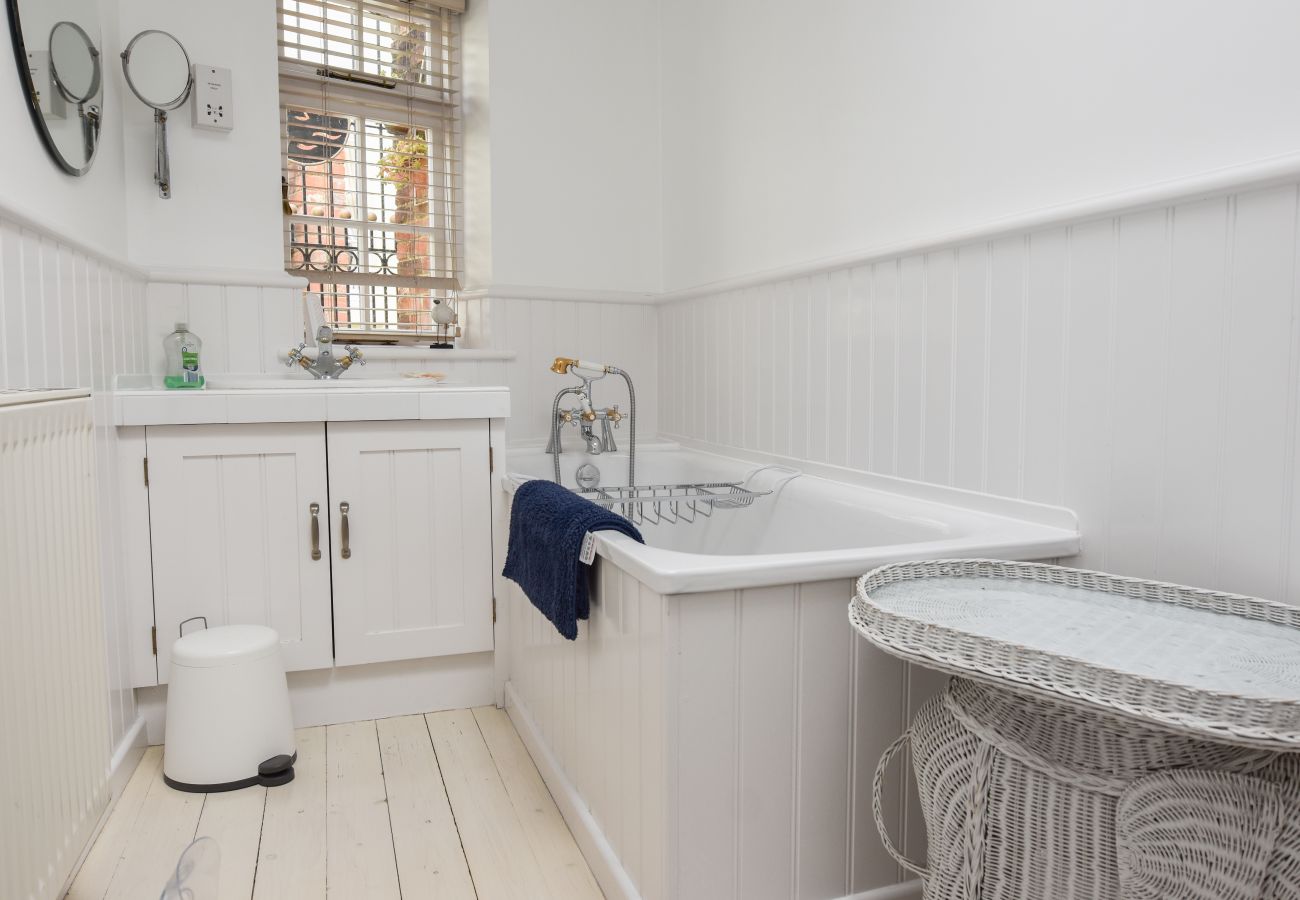 Mulberry Cottage Holiday Home Family Bathroom: Bath and handheld shower, WC and sink with storage
