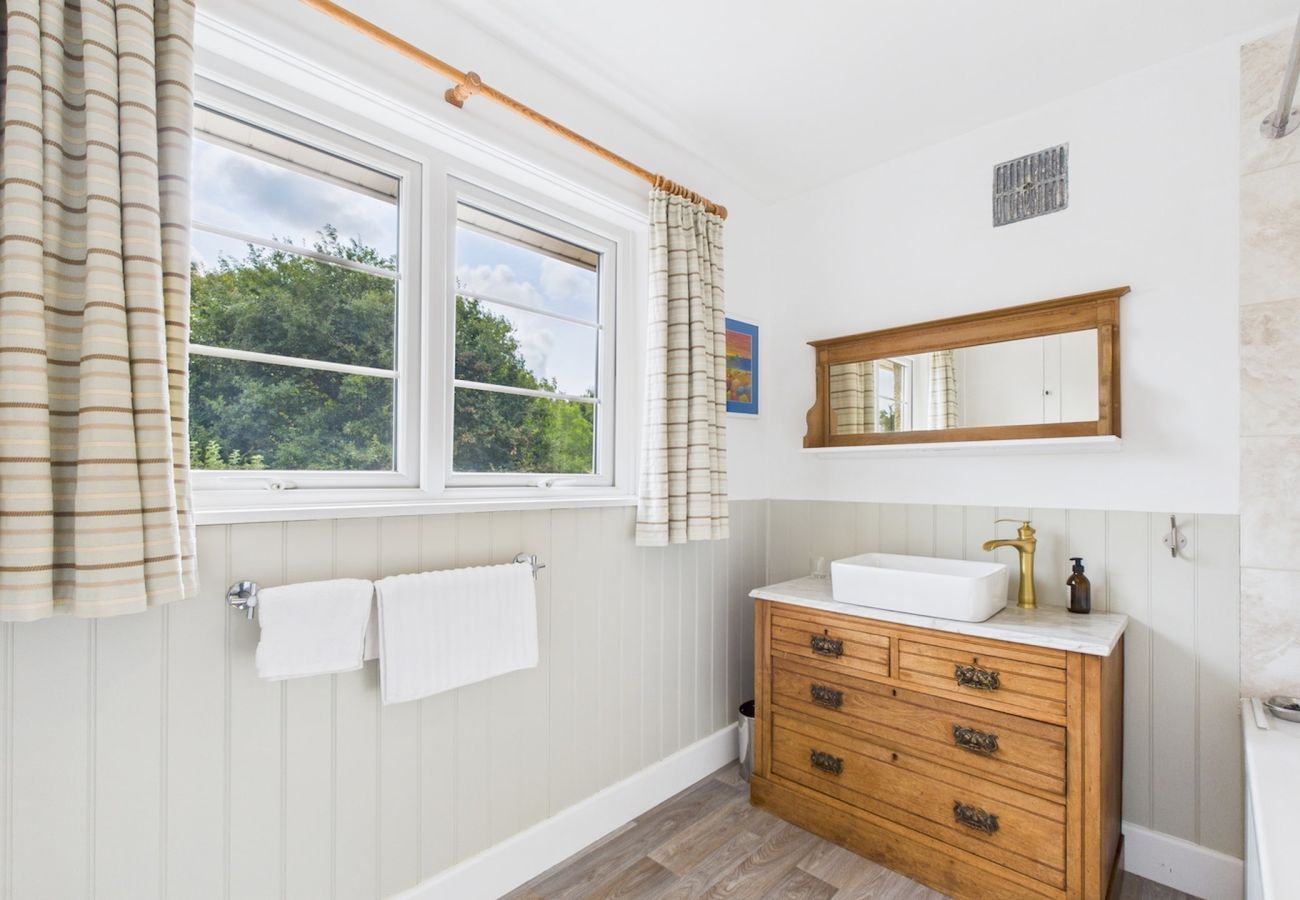  A luxurious bathroom equipped with a shower over the bath at The Timbers, Seaview Holiday Home