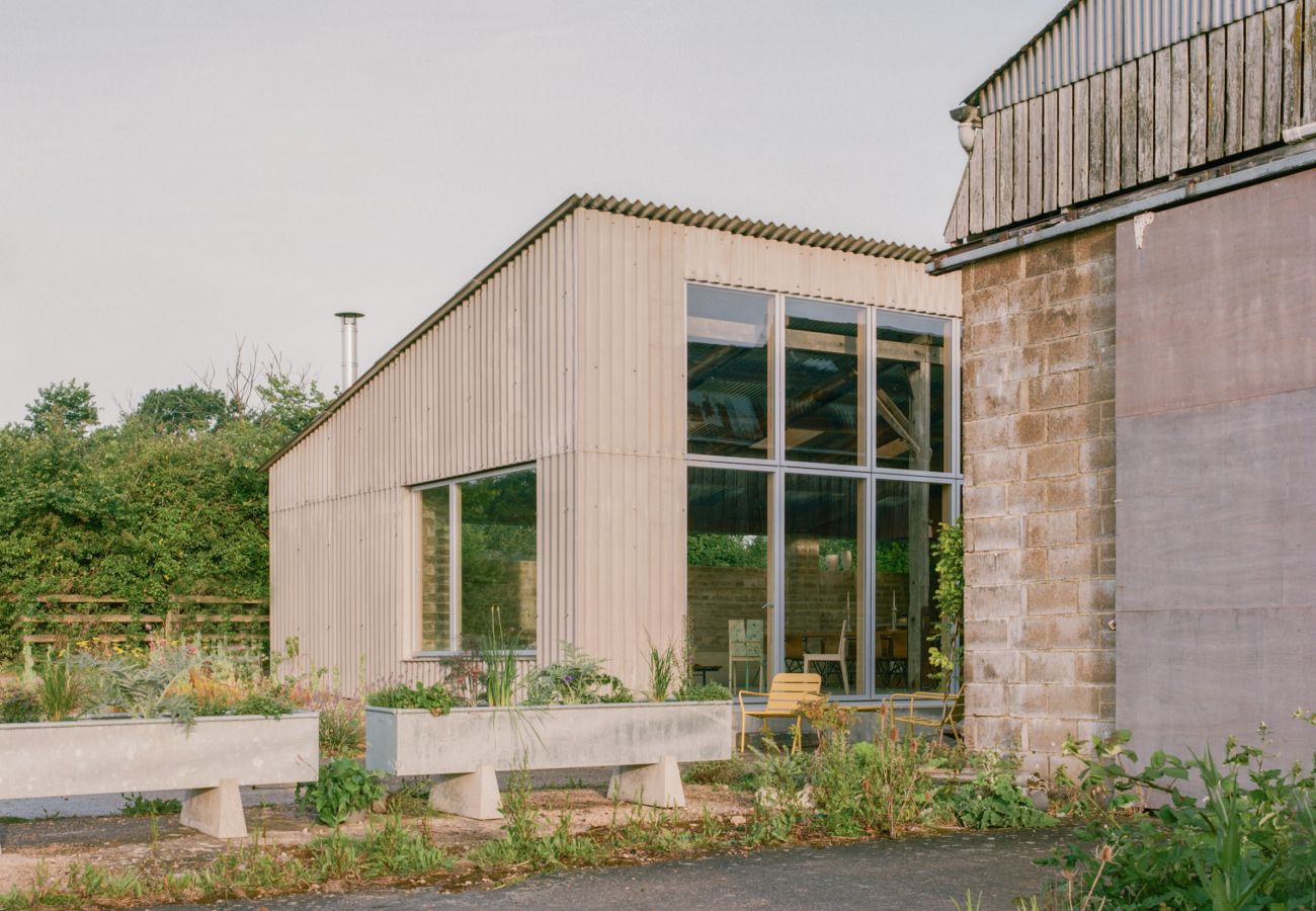Modern barn conversion holiday home with a large garden and glass windows.