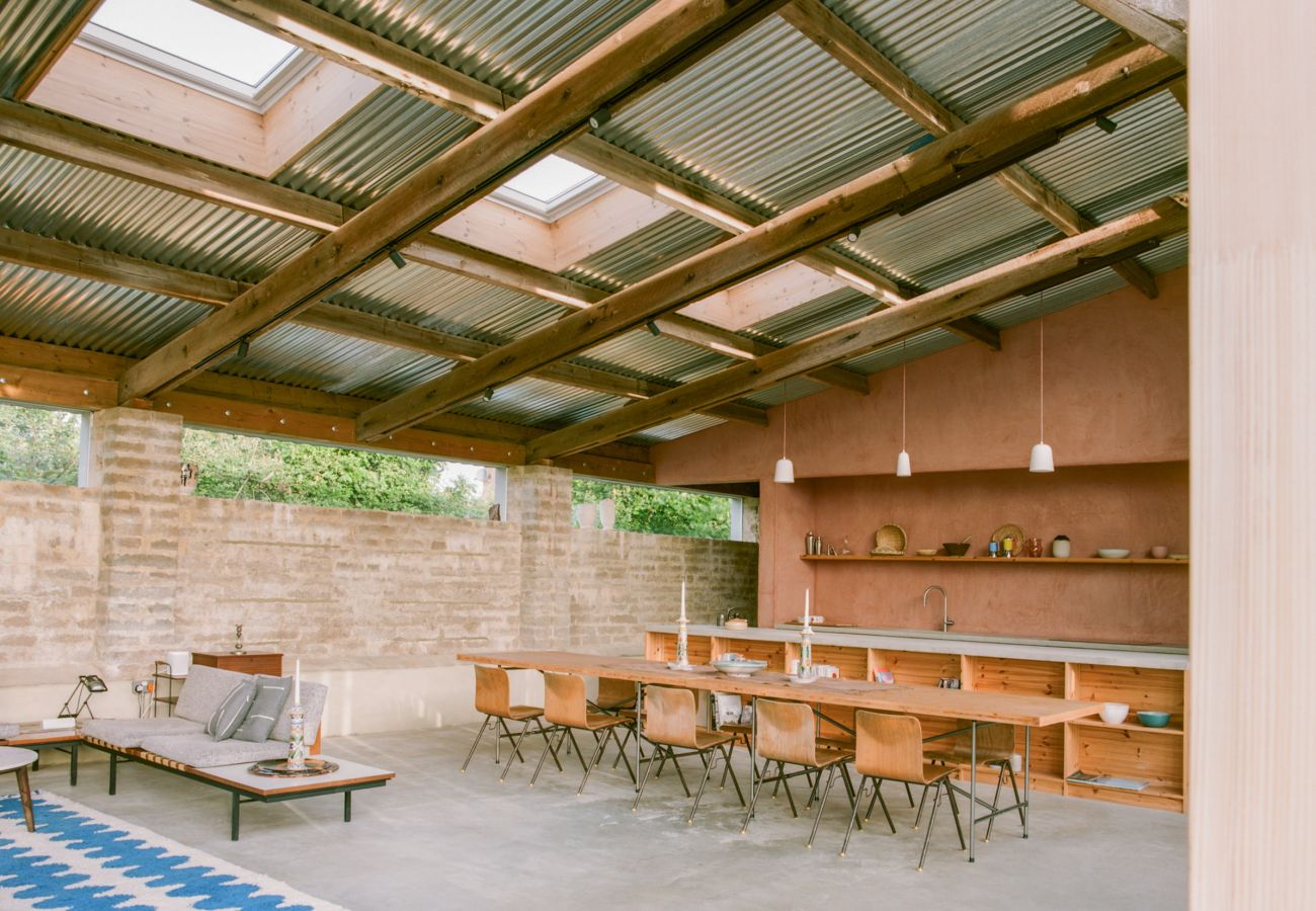 Bright, high-ceilinged holiday home lounge with contemporary furniture and a view of the fields.